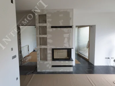 Obloge kamina - Intermont Kutni kamin s dvostranim staklom u naprednoj fazi izgradnje. Vidljiva je djelomično izgletana obloga od vatrootpornih ploča, okomite niše te donji (ulaz hladnog zraka) i gornji (izlaz toplog zraka) crni otvori za prirodnu konvekciju.